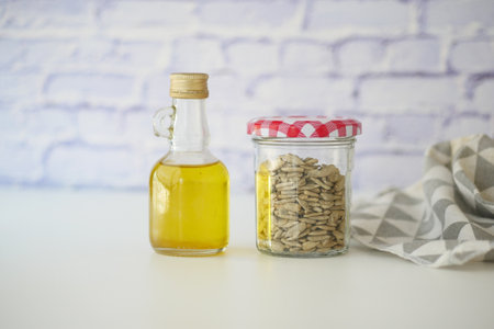 Oil and seeds in mason jar on counter with brick backdropの写真素材