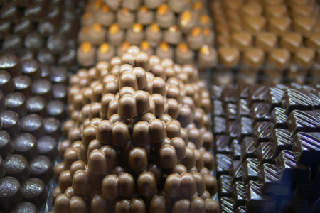 Chocolate confections stacked attractively in display caseの写真素材