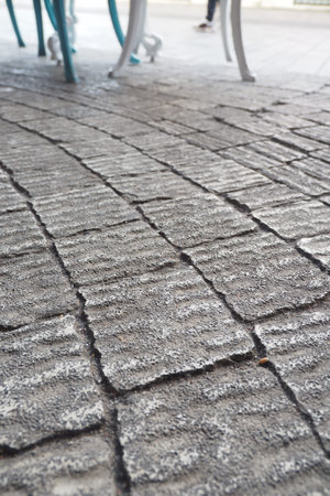 Textured cobblestone pavement with chairs and tables in viewの写真素材