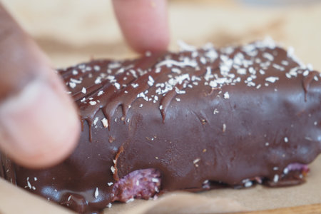 Delicious chocolate treat being touched with fingers at a cafe