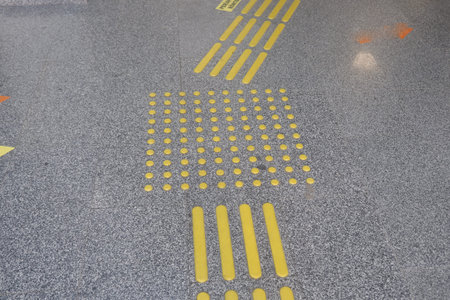 Yellow tactile guide lines on a public space floor in an urban area