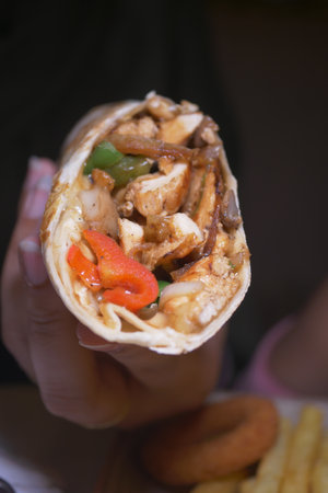 Delicious chicken wrap with vibrant vegetables and spices insideの写真素材