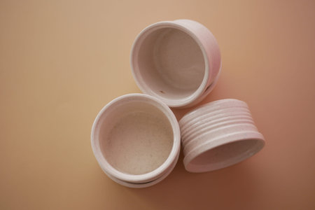 Small white containers stacked on a light background for storage