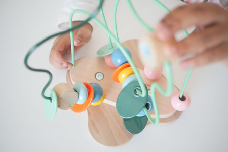 Hands engaged in colorful wooden bead activity for young childrenの写真素材