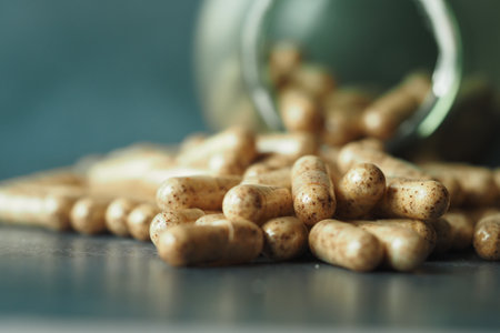 Natural herbal capsules scattered on a dark surfaceの写真素材