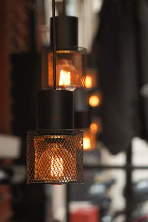 Decorative pendant lights illuminate urban cafe setting at dusk