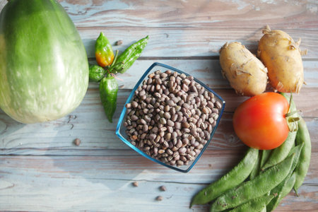 Assorted vegetables and beans arranged on a rustic wooden table