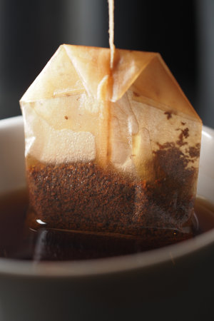 Tea bag steeping in warm cup of black tea by the windowの写真素材
