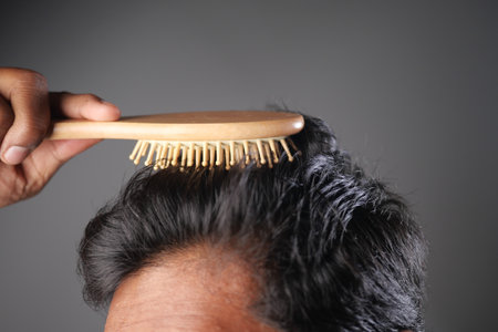 Hair grooming with a wooden brush for a cleaned lookの写真素材