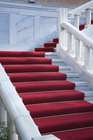Elegant staircase with red carpet leading to a grand entranceの写真素材