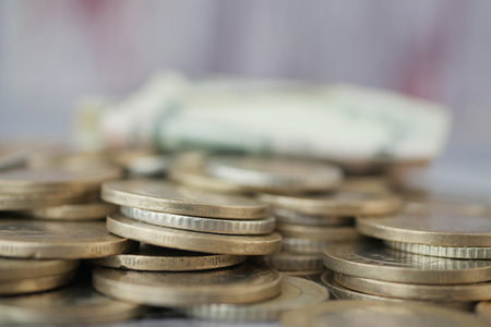 Coins and banknotes arranged on a surface during daylightの写真素材