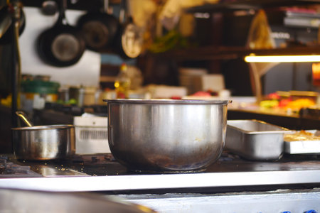 Busy kitchen preparation with steel pots and cooking equipmentの写真素材