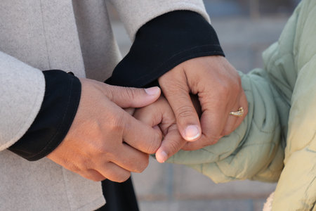 mother hold hands her child in a warm gesture of affection