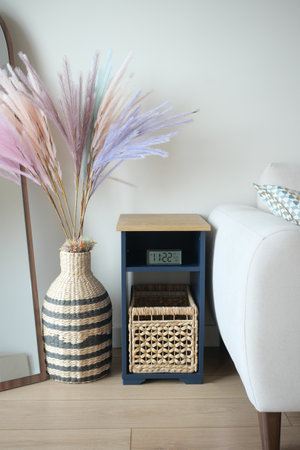 Decorative living room corner with pastel flower arrangement and clockの写真素材