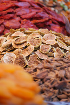 Colorful display of dried fruits at a bustling marketの写真素材