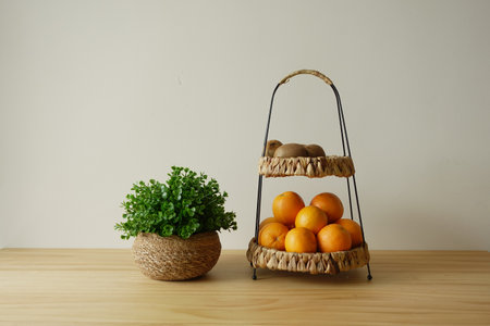 Fresh fruits and greenery on a wooden table in a cozy kitchenの写真素材