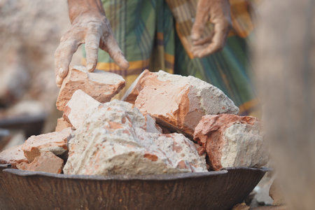 Worker handling clay bricks at a construction site in rural areaの写真素材