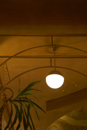 Charming interior lighting above a cozy dining space in the eveningの写真素材