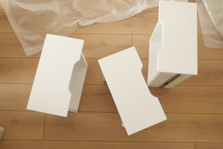 White furniture pieces arranged on a wooden floor in a bright roomの写真素材