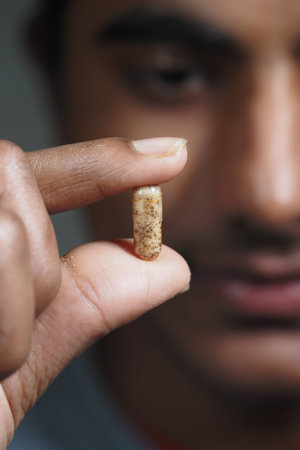 Holding a capsule with curiosity in a close-upの写真素材