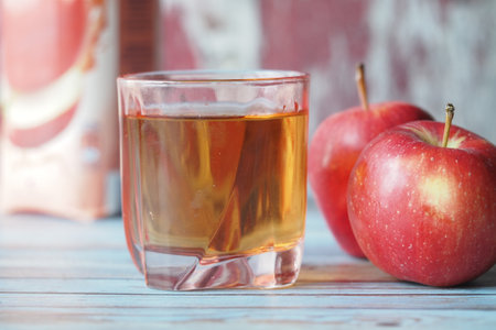 Fresh apple juice served in a glass with ripe apples nearbyの写真素材