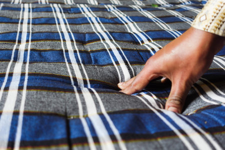 Hand pressing fabric to create texture on a blue striped pattern