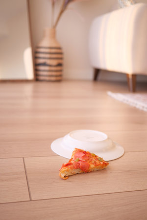 Slice of pizza spilled on the floorの写真素材