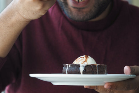 Enjoying dessert with warm chocolate cake and ice cream indoorsの写真素材