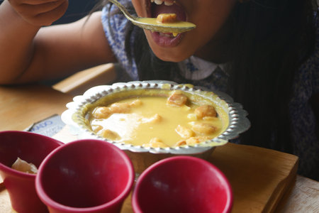 Enjoying a flavorful bowl of warm dessert in a local cafeの写真素材