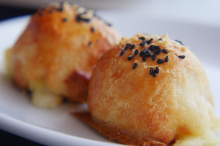 Delicious baked dumplings with sesame seeds served on a plateの写真素材