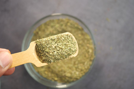 Freshly harvested herbs displayed in a wooden scoop for culinary useの写真素材