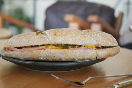 Delicious sandwich with ham and cheese served on a wooden tableの写真素材