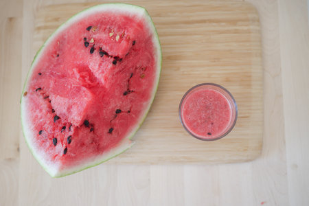 Refreshing watermelon juice preparation on a wooden cutting boardの写真素材