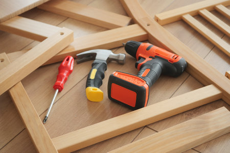 Tools and materials arranged on wooden surface for furniture assemblyの写真素材