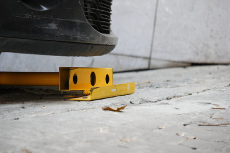Vehicle immobilizer placed under a parked car in a garageの写真素材