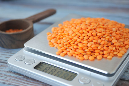 Lentils measured on a digital scale in a kitchen settingの写真素材