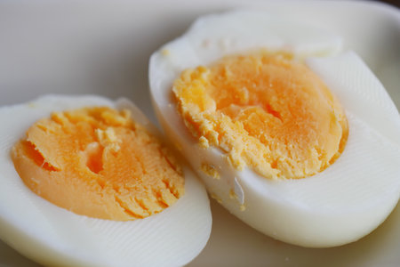 Perfectly cooked soft-boiled eggs on a white plate for breakfastの写真素材