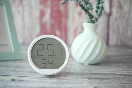 Temperature and humidity display on a wooden table with decorの写真素材