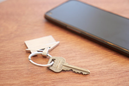 Keys and smartphone on a wooden table in a cozy indoor settingの写真素材