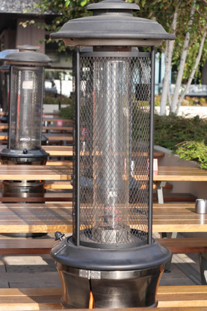 Outdoor heating lanterns illuminating a cozy dining area at duskの写真素材