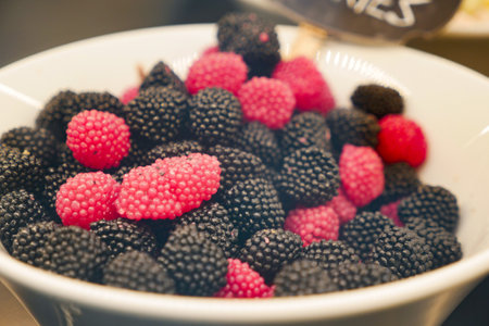 Colorful assortment of fresh berries in a white bowl on displayの写真素材
