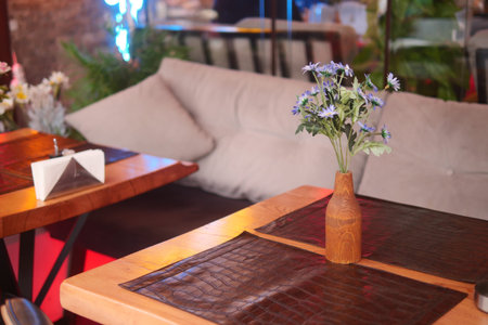 Cozy dining area with decorative flower arrangement at restaurantの写真素材