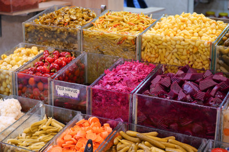 Colorful display of fresh vegetables and pickled goods at marketの写真素材