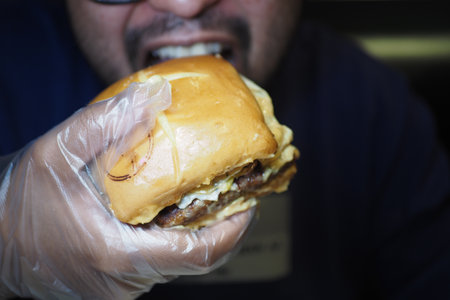 Enjoying a juicy burger at a local restaurant during lunch timeの写真素材
