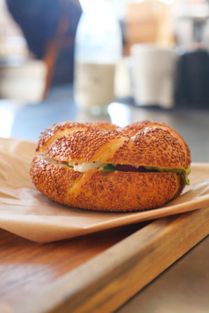 Freshly baked bagel served with creamy filling and fresh greensの写真素材