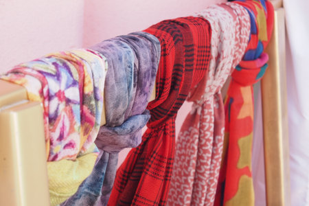 Colorful scarves neatly arranged for display on a clothes rackの写真素材