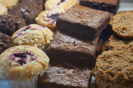Delicious baked goods assortment with brownies and muffins on displayの写真素材
