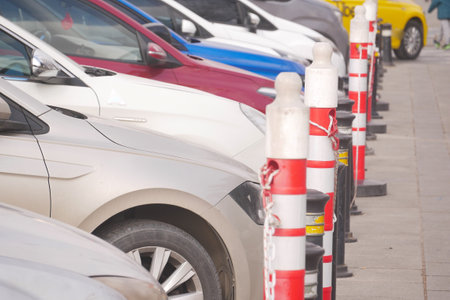 Cars parked in a lot with clear boundary markers at mid-dayの写真素材