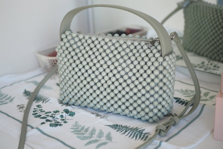 Stylish green beaded handbag on a decorative tableの写真素材