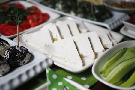 Delicious spread of fresh cheese and vegetables at a buffet tableの写真素材